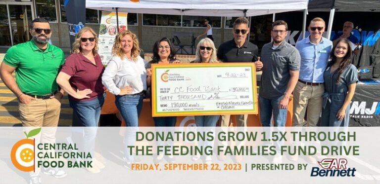 Kym Dildine, CEO, Central California Food Bank, is pictured to the immediate left of the big check presented to the Central California Food Bank. Flanking Kym Dildine are unidentified volunteers for the 10th Annual Feeding Families Fund Drive.