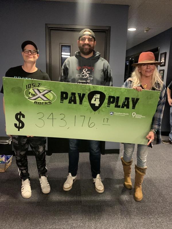 The X's The People's Morning Show team. Left to right: Nipsey, Vince, and Jen Shade, holding up a large "cheque" displaying the $343,176.17 raised for the Harrisburg-York-Lancaster area's Children's Miracle Network in its 17th Annual People's Pay 4 Play Radiothon