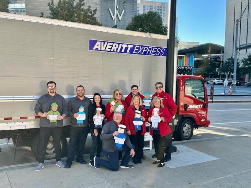 New Country 96.3's 10,000 for the Troops holiday card drive, featuring morning show hosts, Mark "Hawkeye" Louis and Michelle Rodriguez of Hawkeye in the Morning, displaying this year's record number of cards donated, and employees of Averitt